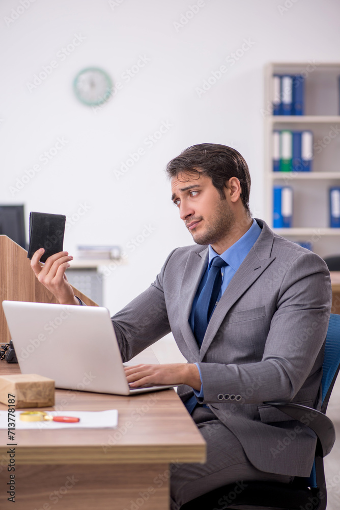 Young male employee in remuneration concept Young male employee in remuneration concept