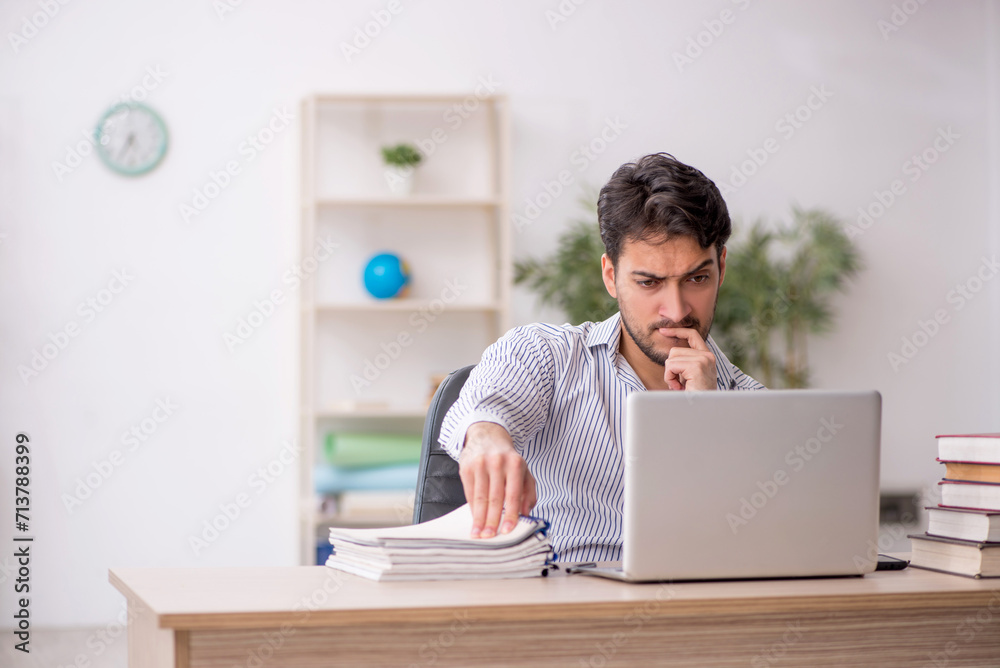 Young male employee student working in the office Young male employee student working in the office