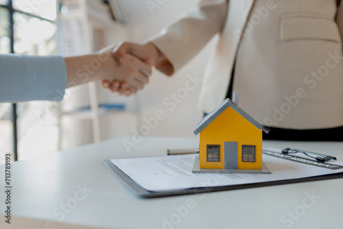 real estate broker manager hand shake to customer after signing contract for buying house, investment, buy and sell house concept, Real estate professionals and clients discussing home purchases,