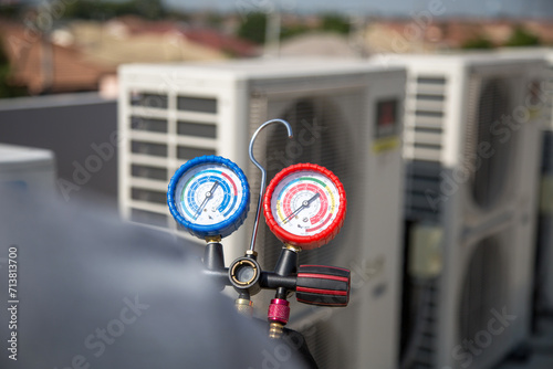 Technician use manifold gauge check and filling refrigerant vacuum pump evacuates industry air conditioning HAVC system maintenance or chiller and air conditioner cleaning filter service. photo