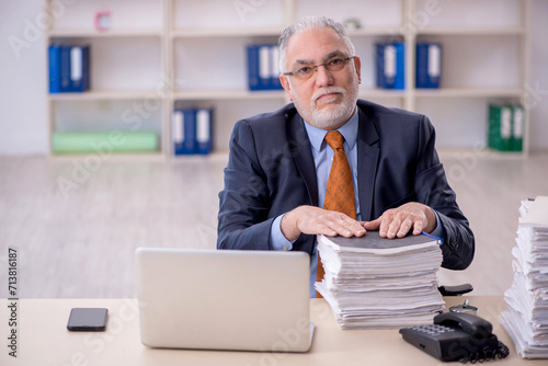 Old male employee unhappy with excessive work in the office