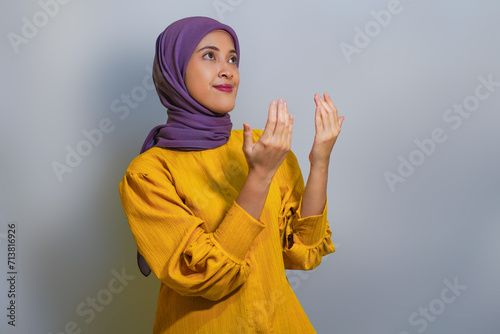 Beautiful young asian muslim woman praying and looking up. religion muslim concept photo