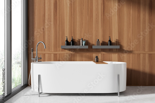Stylish modern bathroom interior with bathtub and accessories, window
