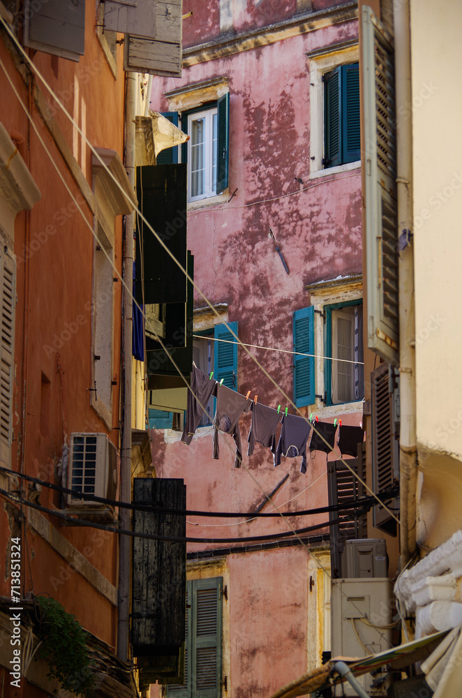 Romantic backstreet, side street or alleys in historic old town of Corfu Island, Greece with Mediterranean style architecture facades, a landmark sightseeing tourist spot in downtown Aegean Sea