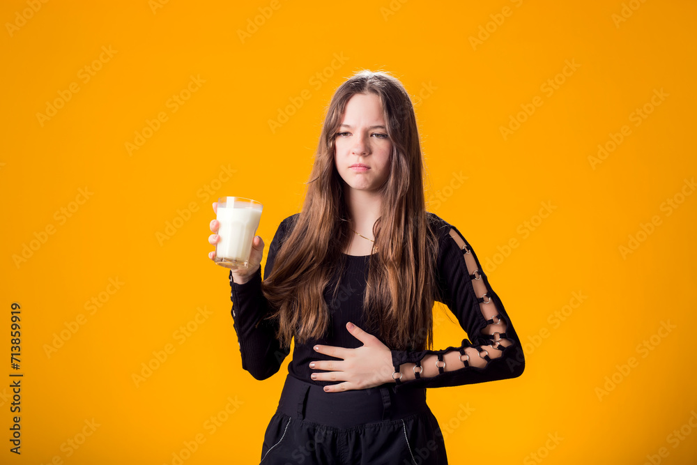 Girl with glass of milk doesn't like it. Dairy Intolerant person. Lactose intolerance, health care concept.