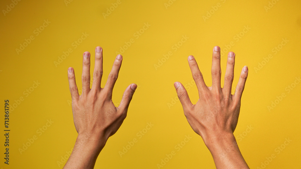 close up of two hands of a Man's Hand on a yellow background