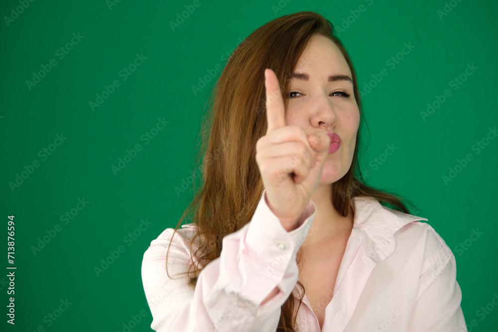 Portrait of a composed young Asian woman wrapped in a white towel against a soft green background, saying no by wagging her finger. High quality photo Portrait of a composed young Asian woman wrapped in a white towel against a soft green background, saying no by wagging her finger. High quality photo
