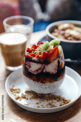 Healthy breakfast with chia strawberry pudding, oatmeal bowl with banana, peanut butter, blackberries, raspberries, nuts, seeds and goji berries