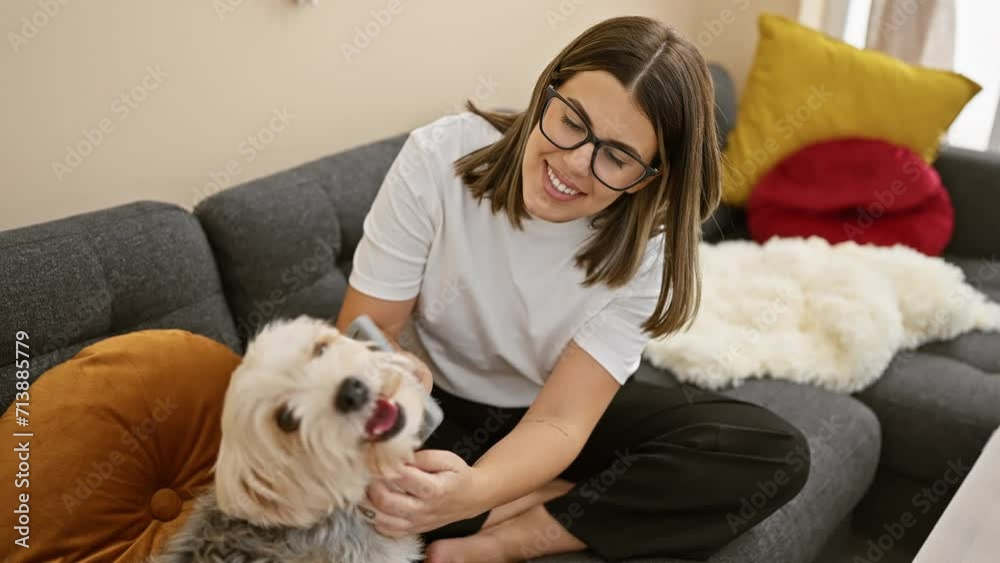 A cheerful woman playing with her fluffy dog in a cozy living room with vibrant cushions and a soft rug. A cheerful woman playing with her fluffy dog in a cozy living room with vibrant cushions and a soft rug.