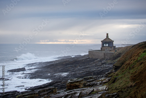 House on a cliff next to wild sea