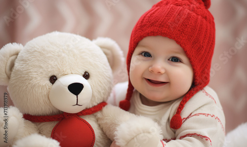 A small laughing child in a red hat is holding a big teddy bear. Concept for Valentine's day celebration.