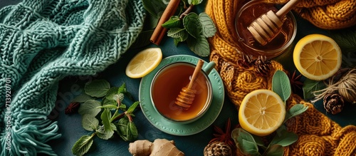 cozy autumn Breakfast with tea selective focus honey cinnamon sticks lemon ginger and a warm knitted sweater on a beige mint fabric. Creative Banner. Copyspace image