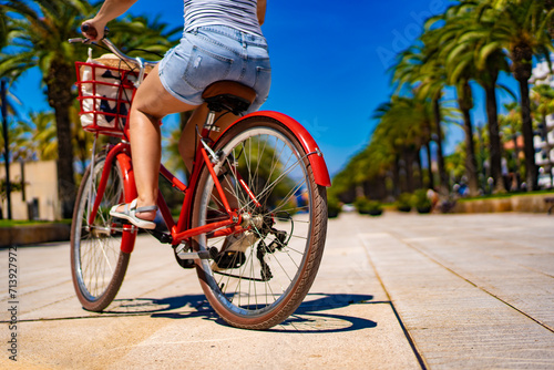 Fototapeta Naklejka Na Ścianę i Meble -  Woman riding bicycle on seaside boulevard Costa Dorada Spain
