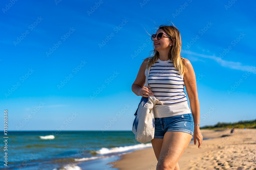 Beautiful mid adult woman walking on sunny beach
Beautiful mid adult woman walking on sunny beach
