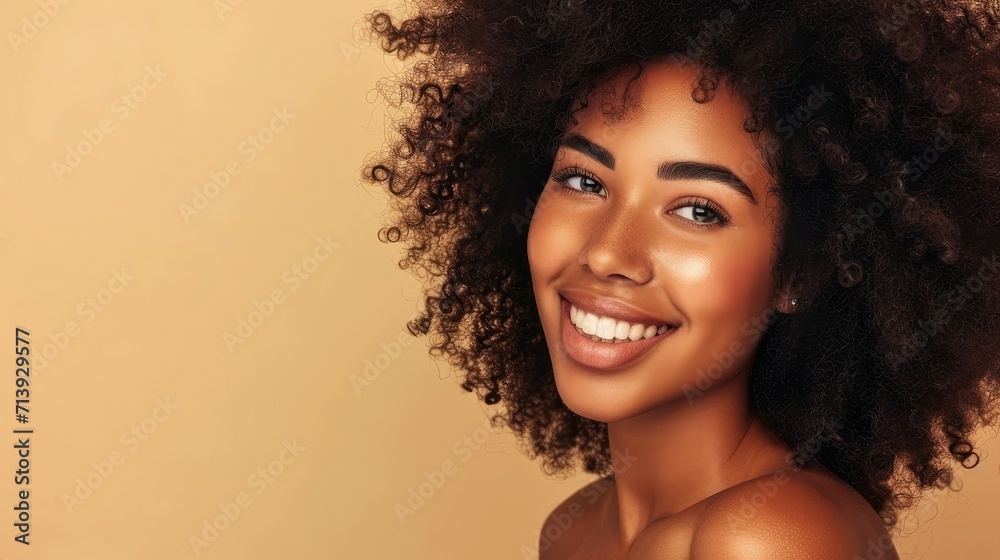 Beauty portrait of african american girl with clean healthy skin on beige background. Smiling dreamy beautiful black woman.Curly hair in afro style