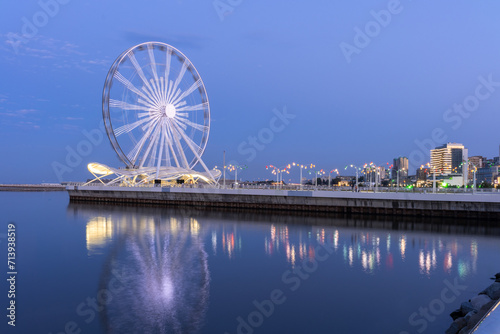 Baku, Azerbaijan - July 30, 2023: A mesmerizing long exposure photograph showcasing the vibrantly lit Ferris Wheel in Baku.