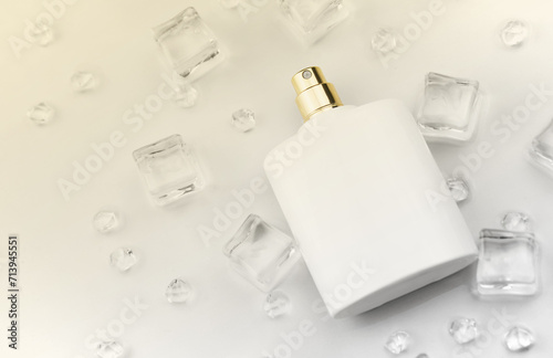 Female perfume mat white bottle, objective photograph of perfume bottle in ice cubes and water on white table. View from above. Mockup product photo, concept of freshness and aroma