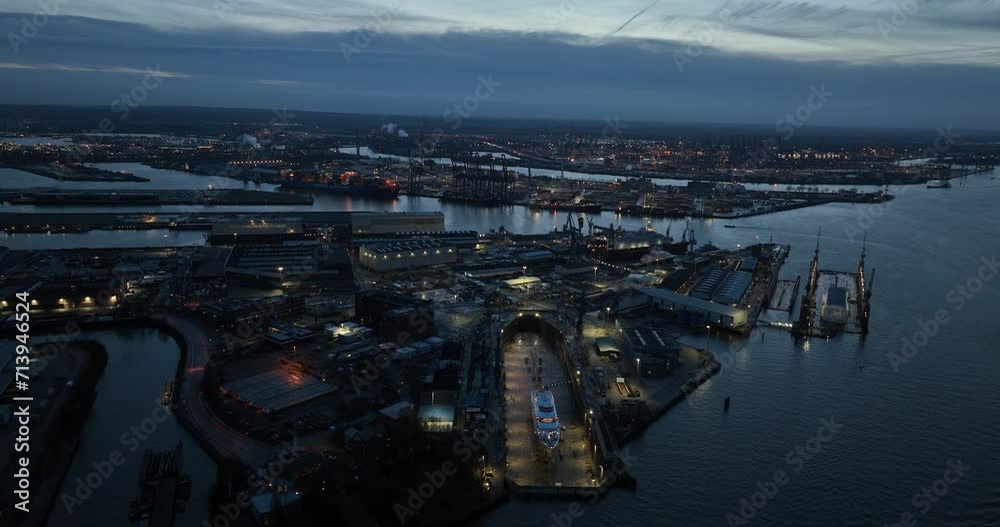 The industrial and commercial port of Hamburg, Germany at dusk. Birds eye aerial drone view. The industrial and commercial port of Hamburg, Germany at dusk. Birds eye aerial drone view.