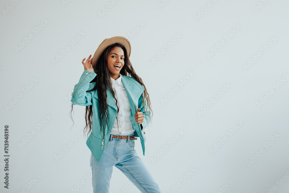 joyful african teenager in a mint jacket and beige hat posing in a spacious bright room. joyful african teenager in a mint jacket and beige hat posing in a spacious bright room.