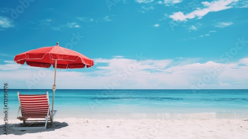 Red umbrella and chair on the tropical beach with blue sky background.