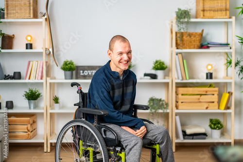 Happy disabled man in wheelchair smiling in the living room photo
