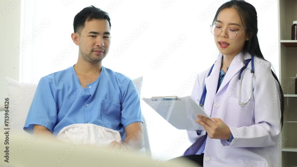 Female doctor talks with a patient while visiting a patient in the hospital. Doctor diagnosing the condition of a patient after surgery who is recuperating in the room. Female doctor talks with a patient while visiting a patient in the hospital. Doctor diagnosing the condition of a patient after surgery who is recuperating in the room.