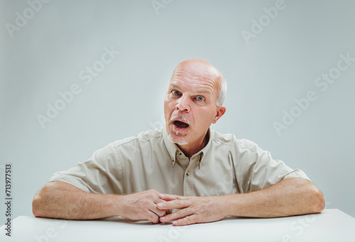 Fotografi Bewildered elder hears news, shows utter astonishment