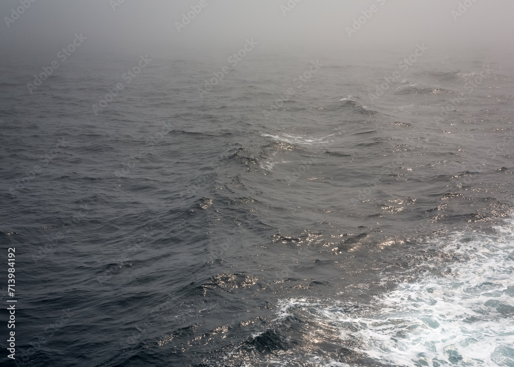 Russia Sakhalin Oblast 27.07.2023 Sea of Okhotsk in the fog The line of the horizon, dissolving in the fog The ship's footprint on the water Space for text. Ripples on the surface and light refracting Russia Sakhalin Oblast 27.07.2023 Sea of Okhotsk in the fog The line of the horizon, dissolving in the fog The ship's footprint on the water Space for text. Ripples on the surface and light refracting
