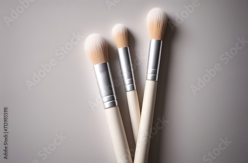 three makeup brushes on a patterned surface. The brushes are neatly arranged with one on top of the other.