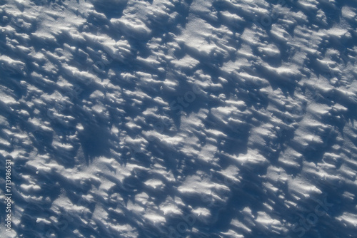 A white snow blanket covers the earth below, glistening in the sunlight