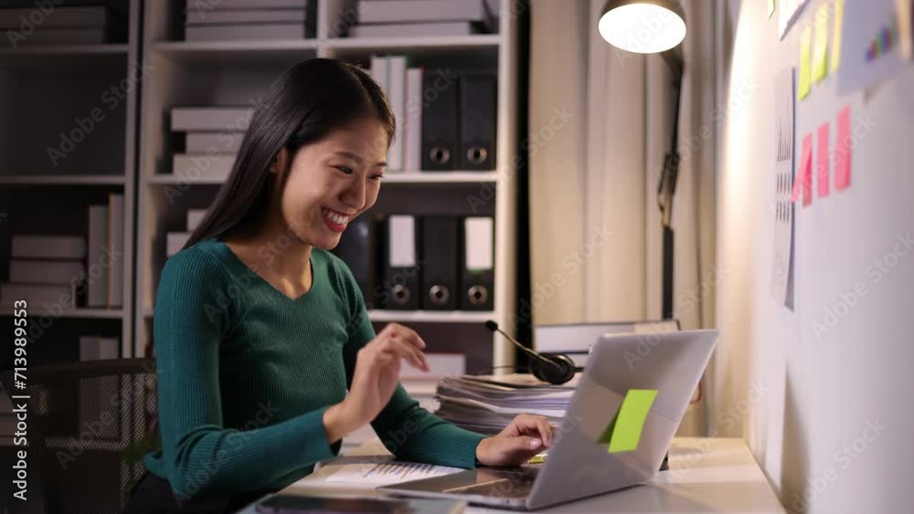Businesswoman working overtime at night in the office. Young Asian woman stretches to relieve fatigue from work. Businesswoman working overtime at night in the office. Young Asian woman stretches to relieve fatigue from work.