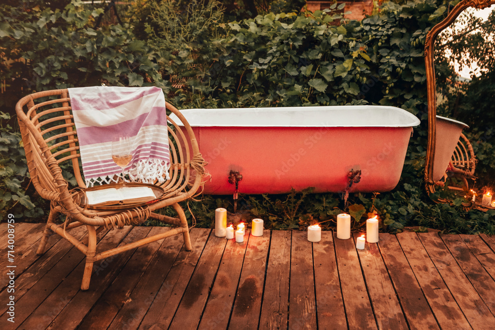 Chair and candles near bathtub in garden