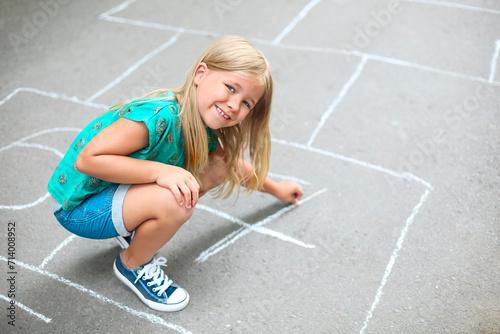 Kid playing hopscotch on playground outdoors