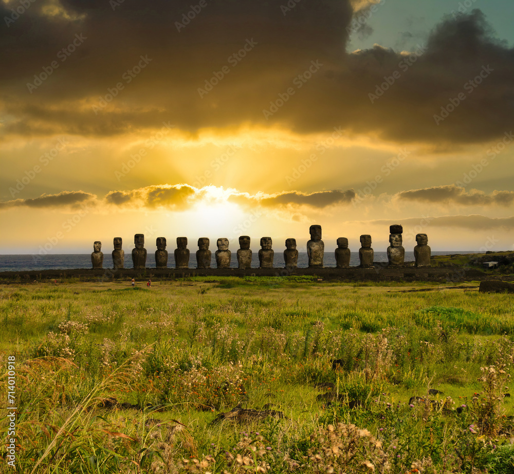 An evocative group of Moai statues illuminated by the light of dawn on the mysterious Easter Island (Rapa Nui), Chile