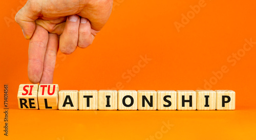 Relationship or situationship symbol. Concept word Relationship situationship on wooden cubes. Beautiful orange background. Businessman hand. Business relationship situationship concept. Copy space.