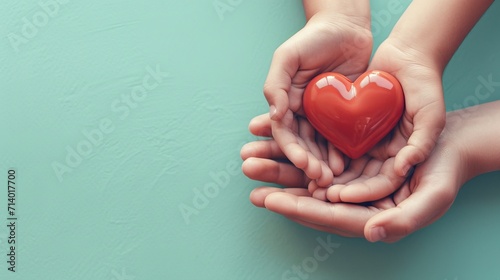 adult and child hands holding red heart on aqua background, heart health, donation, CSR concept, world heart day, world health day, family day 