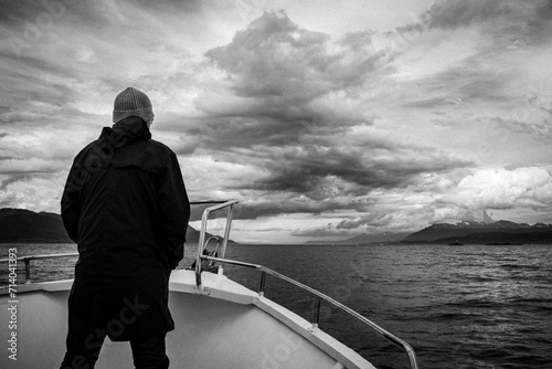 Marinero navegando por el canal de Beagle, parado en Proa y mirando el horizonte photo