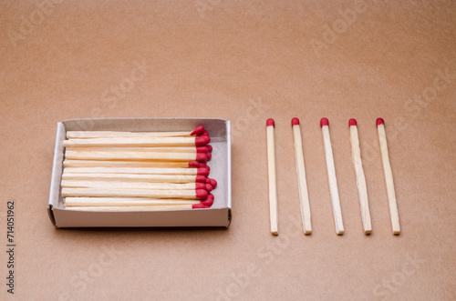 Set of new unlit matchsticks in a matchbox orderly aligned on natural brown paper background