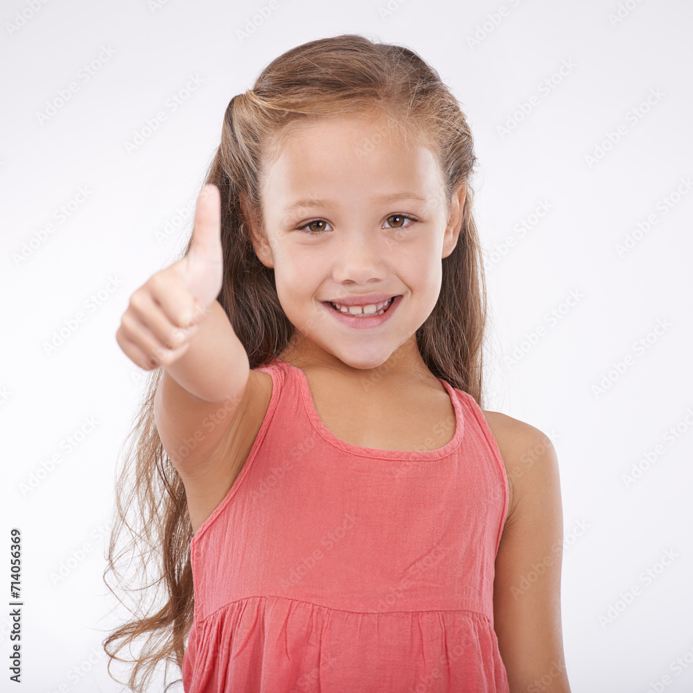 Thumbs up, kid and portrait of girl in studio for winner, achievement or celebrate success on white background. Happy child, emoji or like sign for yes, feedback or thank you for agreement of support Thumbs up, kid and portrait of girl in studio for winner, achievement or celebrate success on white background. Happy child, emoji or like sign for yes, feedback or thank you for agreement of support