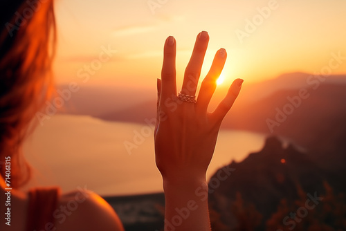 New year planning and vision concept, Close up of woman hand touches the sunset sun the fingers. Female capturing the sunrise. copy space. Romantic concept.