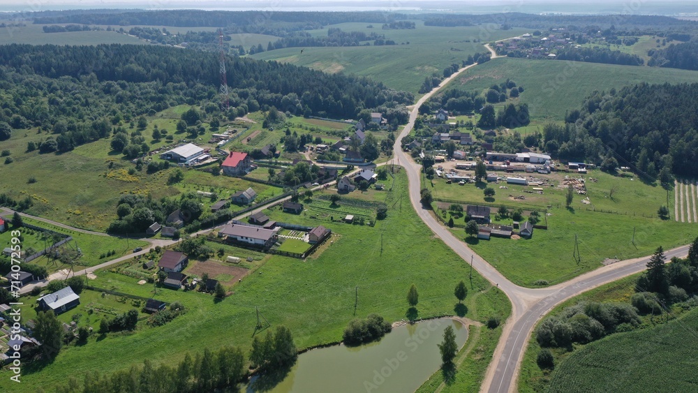 An aerial view of the crossroads of rural roads connecting villages outside the city. A network of sandy dirt roads in the countryside in summer. Junction, crossroads outside the city. Fields, forests