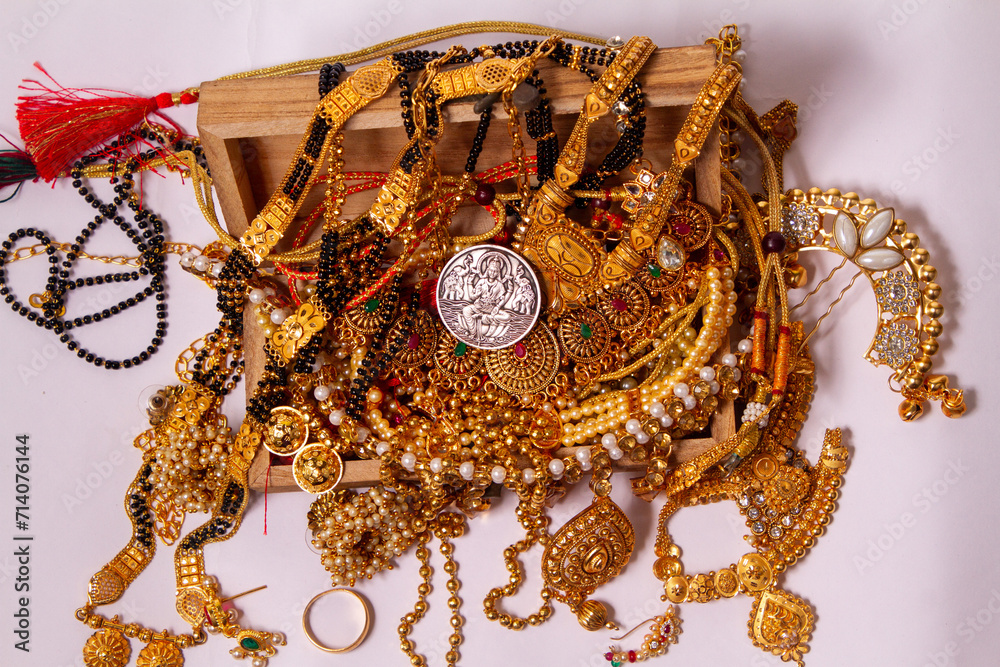 Φωτογραφία gold jewelery IN wooden Durga, Saraswati or laxmi silver coin isolated on white background