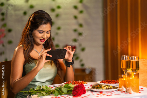 Photography Happy indian girl at candlelight dinner talking photos of decorated dinner at re
