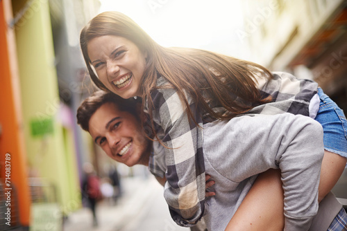 Happiness, hug and portrait of couple piggyback ride for fun urban adventure, bonding and city journey. Wellness, embrace and young man, woman or people smile for relationship, goofy game or break photo
