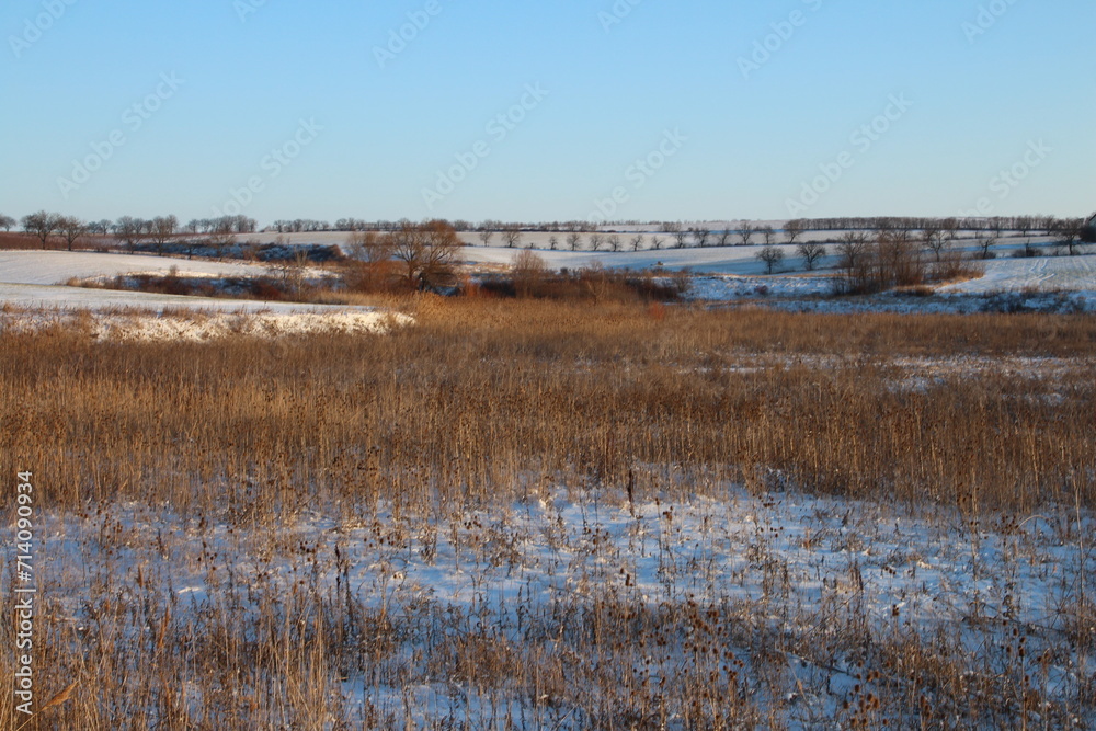 A field with a river and a bridge in the distance A field with a river and a bridge in the distance