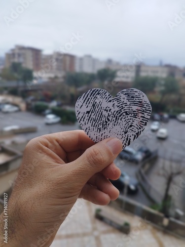 Amore maschile san Valentino foto concetto - Mano di un uomo tiene un cuore tra le dita