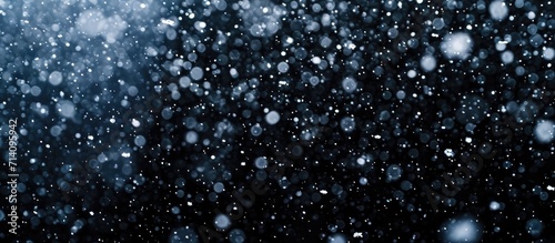 Snowstorm stock image with falling snow on black background.