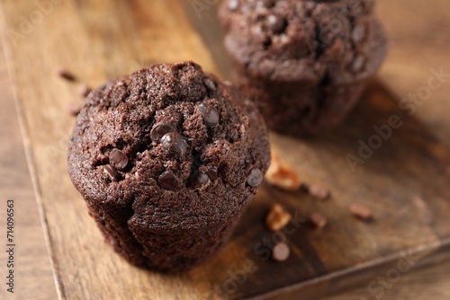 Delicious chocolate muffins on wooden table, closeup