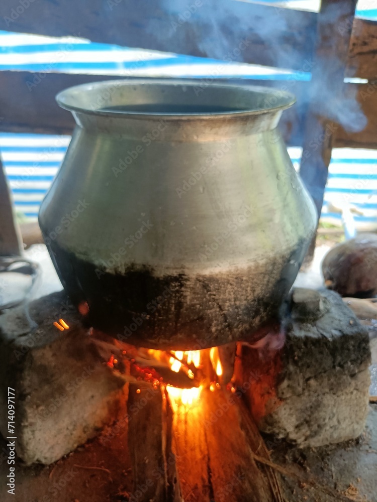 Water is boiled in an aluminum pot to cook food. Water is boiled in an aluminum pot to cook food.