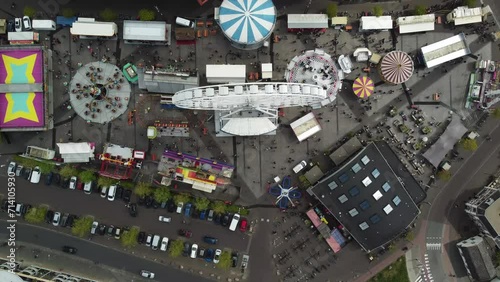 High altitude aerial view of fair showing funfair attractions like ferris wheel and wave swinger is amusement ride that is a variation on the carousel in which the seats are suspended from rotating 4k photo